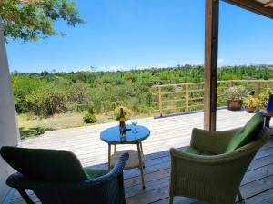 eine Terrasse mit 2 Stühlen und einem Tisch auf einer Terrasse in der Unterkunft Caracal Cottage in Plettenberg Bay