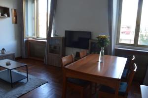 a living room with a wooden table with a vase of flowers at Appartamento La Vecchia Ferrovia in Castellammare di Stabia