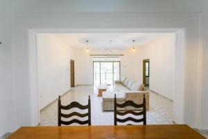 a living room with a couch and a table at Dias Legacy Bungalow in Talpe