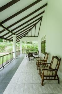 a large porch with chairs and tables on it at Dias Legacy Bungalow in Talpe
