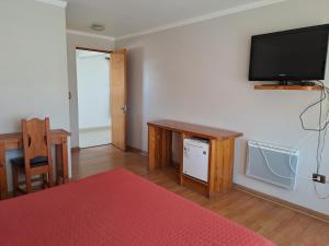 un soggiorno con una TV a schermo piatto su una parete di Hotel Solaris a Huasco