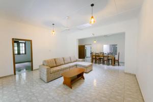 a living room with a couch and a table at Dias Legacy Bungalow in Talpe
