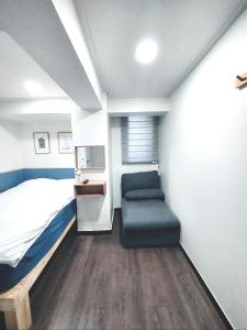 sypialnia z łóżkiem i krzesłem w obiekcie One Minute Guesthouse w Seulu