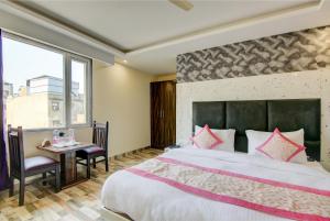 una camera da letto con un letto grande e un tavolo di Smart Plaza Hotel a Nuova Delhi