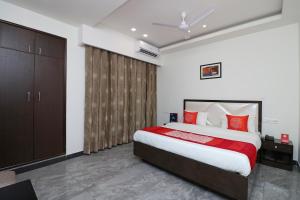 a bedroom with a large bed with red pillows at Jagat Residency in Rājpur