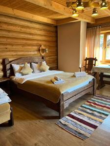 um quarto com uma cama num quarto com paredes de madeira em Knyazhyj Dvir em Yaremche