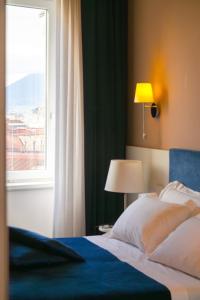 sypialnia z dużym łóżkiem i oknem w obiekcie Palazzo Cappuccini Art Relais w mieście Napoli