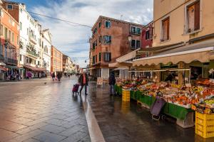 a street with a fruit and vegetable stand on a city street at Fenix Colombina in Biennale - Your little house in Venice