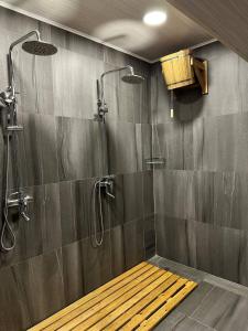 a bathroom with a shower with a bench in it at Sun Rise inn in Karagandy