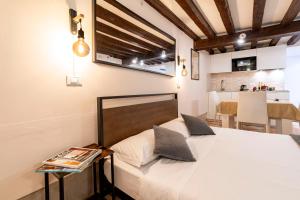 a bedroom with a bed and a table and a kitchen at Fenix Colombina in Biennale - Your little house in Venice