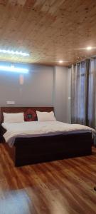 1 cama grande en un dormitorio con suelo de madera en Castle villa en Shimla