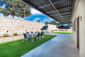 a patio with a table and chairs under awning at אחוזת רעות in ‘En Ha‘Emeq