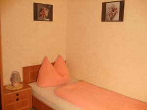 イムストにあるApart-Haus-Florian-Terrassenappartementのベッドルーム1室(壁に2枚の写真が飾られたオレンジ色のベッド1台付)