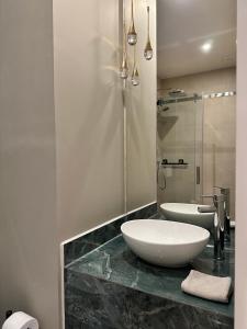 een badkamer met een witte wastafel en een spiegel bij Tiny House Bos in Moergestel