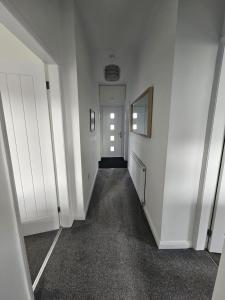 einen leeren Flur mit Tür und Spiegel in der Unterkunft Langley Park House, Durham in Langley Park