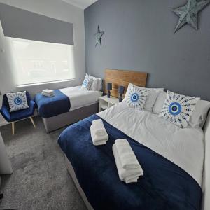 1 Schlafzimmer mit 2 Betten mit blauen und weißen Kissen in der Unterkunft Langley Park House, Durham in Langley Park