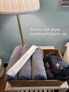 kosz z ręcznikami, lampką i suszarką do włosów w obiekcie One Minute Guesthouse w Seulu