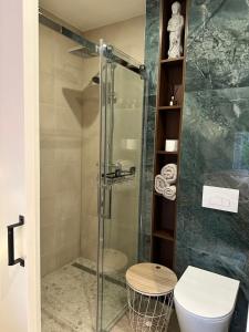 a bathroom with a glass shower with a toilet at Tiny House Bos in Moergestel