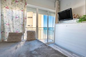 a living room with a tv and a balcony at La Perla in Fuengirola