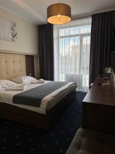 Habitación de hotel con cama y ventana grande en Sun Rise inn, en Karagandá