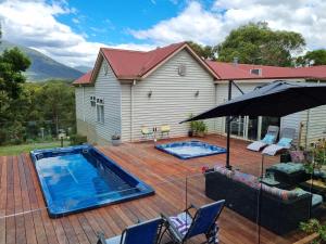 a patio with a swimming pool and an umbrella at Rosebank Guesthouse in Healesville