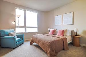 een slaapkamer met een bed en een blauwe stoel bij Priceless & Comfy 3BDR & 3BTH LA in Los Angeles