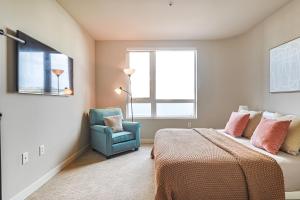 een slaapkamer met een bed en een blauwe stoel bij Priceless & Comfy 3BDR & 3BTH LA in Los Angeles