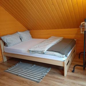 Cama en habitación con techo de madera en 3 kroki od sosny Domek w lasku Sitaniec, en Zamość