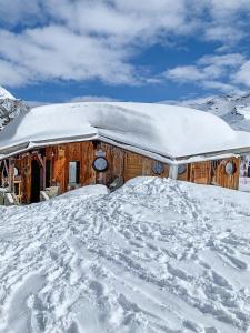 a snow covered log cabin with a snow covered roof at Chalet Flocon - luxury ski chalet by Avoriaz Chale in Avoriaz