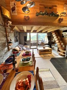 Chalet Flocon - luxury ski chalet by Avoriaz Chale في أفورياز: غرفة طعام مع طاولة مع طبق من الطعام