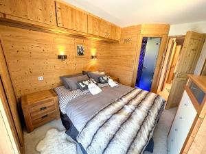 a bedroom with a bed in a wooden room at Chalet Flocon - luxury ski chalet by Avoriaz Chale in Avoriaz