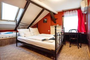 a bedroom with a bed and a desk and two windows at Gul Baba Saray Apartments in Budapest