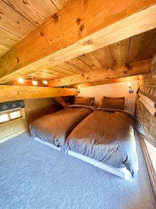 Chalet Flocon - luxury ski chalet by Avoriaz Chale في أفورياز: غرفة نوم بسريرين في سقف خشبي