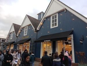 una multitud de personas caminando delante de una tienda en 3BR House with garden near Bicester Village, en Bicester