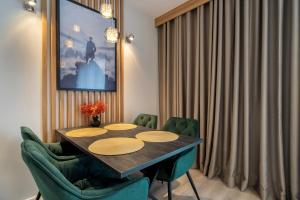Un comedor con una mesa y sillas verdes. en RentPlanet - Apartamenty Zakopiańskie II, en Zakopane