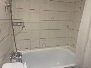 een badkamer met een wit bad en een toilet bij Montmartre Sacré Cœur - Appartement Martyrs in Parijs