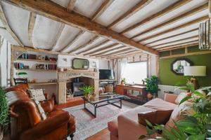 uma sala de estar com um sofá e uma lareira em Micawber Cottage, Rattlesden em Rattlesden