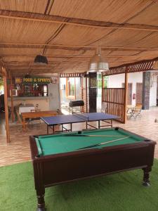 2 mesas de ping pong en un patio con mesa de billar en Dreamers Lodge en Prampram