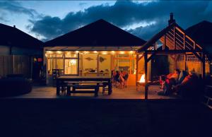 ein Haus mit einem Picknicktisch und einer Gruppe von Personen in der Unterkunft West Wittering Family Home in West Wittering