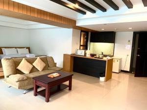 un soggiorno con divano e letto di Tanawit HuaHin Hotel a Hua Hin