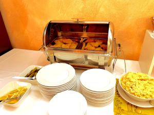 uma mesa com pratos brancos e um buffet de comida em Golf Hotel Karolina em Karlovy Vary