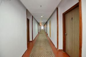 um corredor vazio com um longo corredor com paredes brancas em Hotel Clarks Grand , Gorakhpur em Gorakhpur