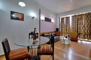 uma sala de estar com uma mesa de vidro e um sofá em Hotel Clarks Grand , Gorakhpur em Gorakhpur
