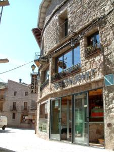 un edificio de ladrillo con una tienda en una calle en Hostal La Muntanya, en Castellar de NʼHug