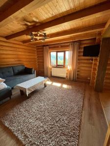 uma sala de estar com um sofá azul e um tapete em Knyazhyj Dvir em Yaremche