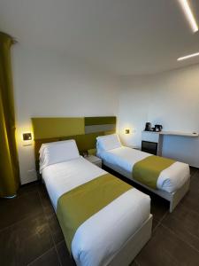 2 Betten in einem Hotelzimmer mit 2 Schlafzimmern in der Unterkunft Joyfül Accomodation in Finale Ligure