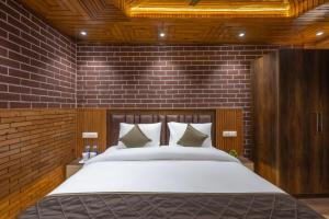 DagshaiにあるFarmville,Homestay, Dharampur, Kasauli Hillsのレンガの壁に大きなベッドが備わるベッドルーム1室が備わります。