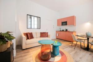 a living room with a couch and a table at Le Laurencin Sens - La Verrière in Sens