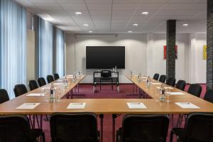 Sala de conferencias con mesa grande y TV de pantalla plana en Amedia Express Bielefeld, Trademark Collection by Wyndham en Werther