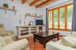 sala de estar con sillas, mesa y TV en Aubadallet, en Vilafranca de Bonany